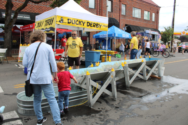 Camas-Washougal Rotary Club member Randal Friedman (center) helps operate the Ducky Derby duck flume Friday, July 22, 2022, during the 2022 Camas Days celebration.