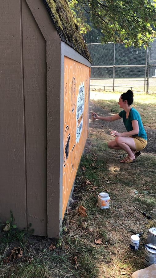 Camas resident Kadie Frazier paints a mural on the side of a an East County Little League shed at Lower Hathaway Park in Washougal in July 2022.