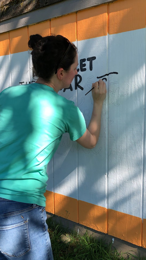 Camas resident Kadie Frazier paints a mural on the side of a shed at Lower Hathaway Park earlier this summer.