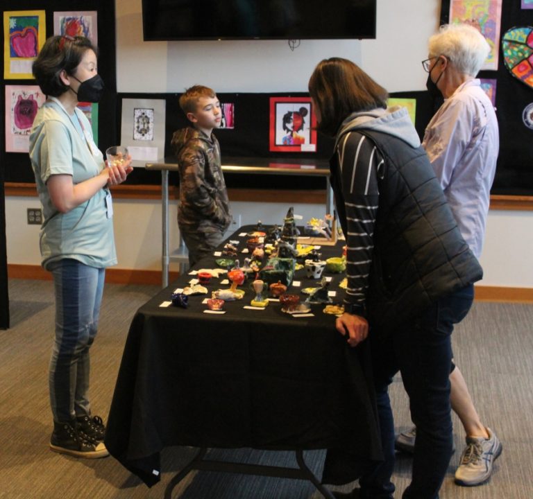 Cape Horn-Skye  Elementary and Canyon Creek Middle school art teacher Alice Yang (left) talks to attendees of the 2022 Washougal Youth Arts Month gallery at Washougal High School in March 2022. The Washougal Art and Culture Alliance named Yang as the group&#039;s 2022 Community Member of the Year.