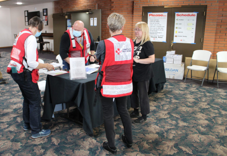Volunteers with the American Red Cross Cascades Region, including Ralph Harris (second from left) and Shirley Toth (left), work to help Nakia Creek Fire evacuees at the Camas Church of the Nazarene on Monday, Oct. 17, 2022.