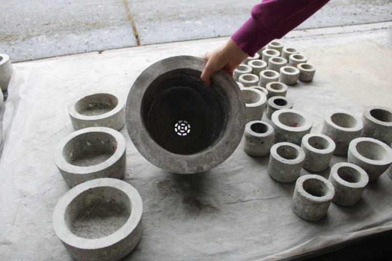 Camas artist Claire Bandfield shows one of her hand-cast stone planter pots that includes a drain inside her Camas art studio on Monday, Oct. 31, 2022. Although the stone pots do not require such a drain, Bandfield said some people prefer them.
