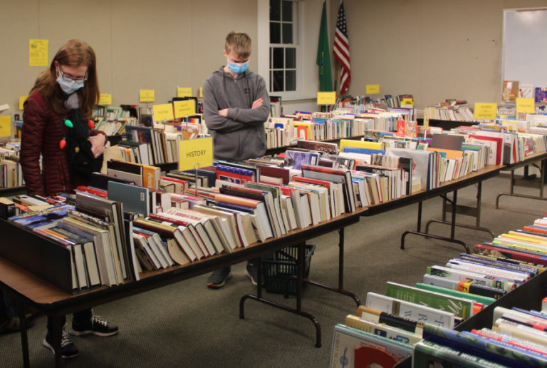 Visitors explore a used book sale at the Camas Public Library during the 2021 Hometown Holidays celebration on Dec. 3, 2021.