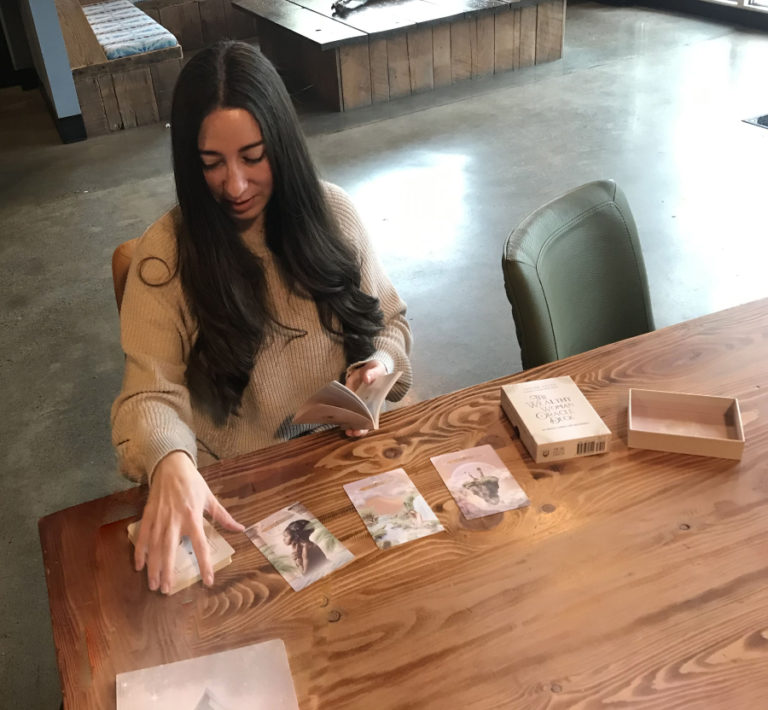 Washougal resident Taylor Eaton demonstrates how to use &quot;The Wealthy Woman Oracle Deck&quot; at Washougal Coffee Company on Tuesday, Dec. 13.