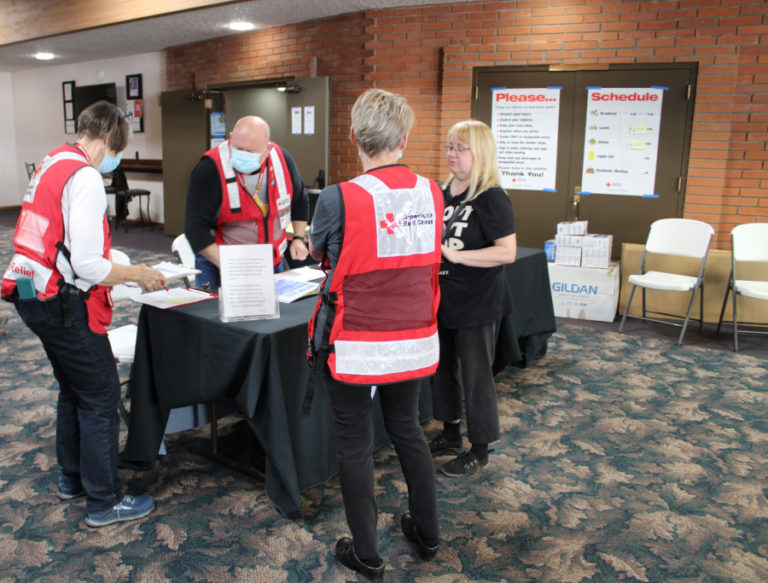 Volunteers with the American Red Cross Cascades Region, including Ralph Harris (second from left) and Shirley Toth (left), work to help Nakia Creek Fire evacuees at the Camas Church of the Nazarene on Monday, Oct. 17, 2022.