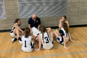 Jemtegaard Middle School seventh-grade girls basketball coach Eric Johnson (center) talks to his team during a game in December 2022. (Contributed photos courtesy of Jemtegaard Middle School)
