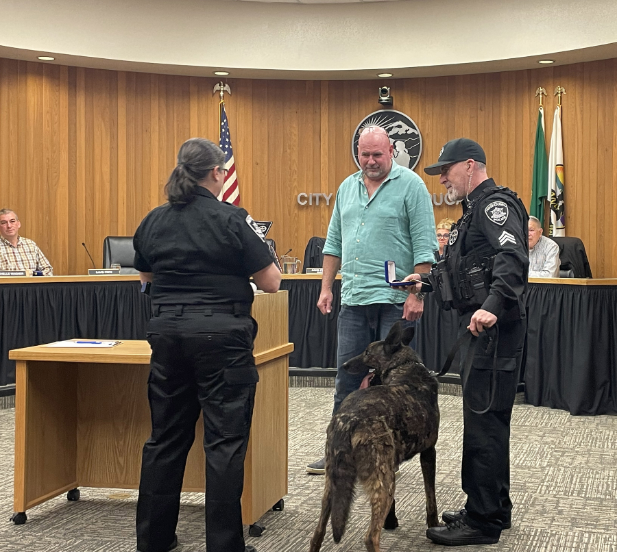 Washougal Police Department detective sergeant Kyle Day (right) receives an award of merit for his canine companion Ranger, as WPD Chief Wendi Steinbronn (left) and Washougal Mayor David Stuebe look on, during a Washougal city council meeting on Monday, Jan. 9. (Contributed photo courtesy city of Washougal)