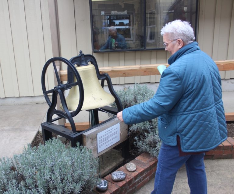 Two Rivers Heritage Museum volunteer Karen Johnson rings an old school bell at the museum on Friday, Feb. 17, 2023. The bell used to hang in the belltower of the one-room Forest Hill School, which consolidated with the Washougal School District in 1928.