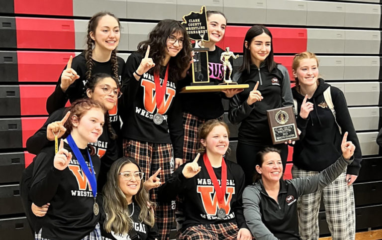 Washougal High School girls wrestling coach Heather Carver (bottom row, far right) and the Panthers celebebrate after winning a sub-regional tournament championship in February 2023.