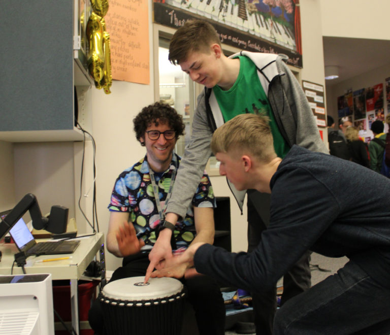 Camas High School choir teacher Ethan Chessin (left) drums with students Liam Hillyard, 16, (center) and Brian Bishop, 18, following the students' first-period choir class on Friday, March 17, 2023.