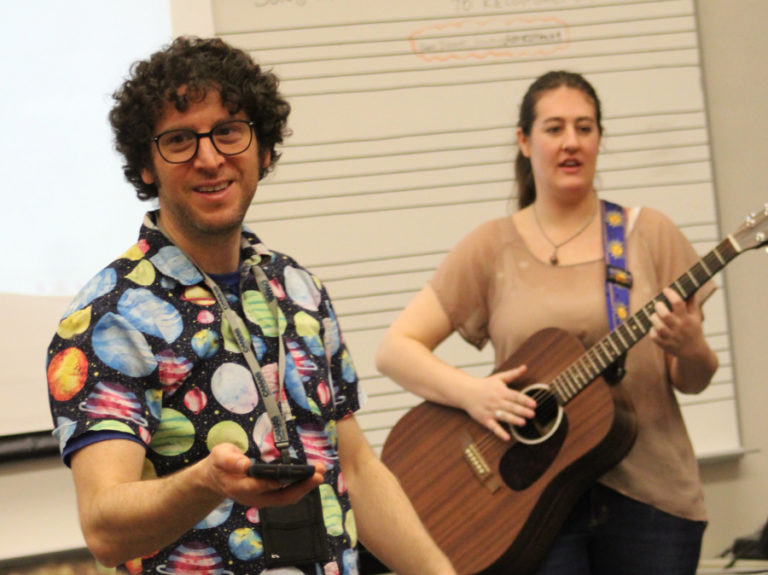 Camas High School choir teacher Ethan Chessin (left) instructs students during his first-period choir class on Friday, March 17, 2023, while visiting musician Becca Larsen (right) looks on.