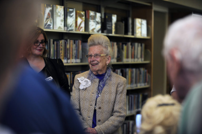 Camas historian Virginia Warren, center, and Camas Public Library Executive Director Connie Urquhart, left, greet a crowd gathered at the Camas Public Library in April 2019, during the unveiling of Warren's extensive Camas memorabilia collection.
