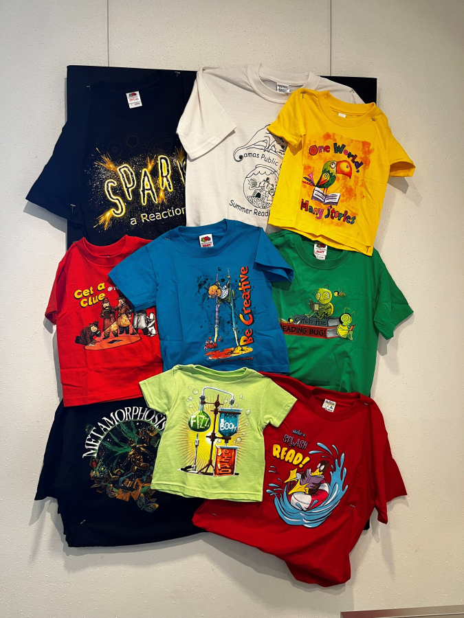 A collection of T-shirts hangs inside the Camas Public Library's Second Story Gallery, celebrating the library's history of summer reading programs, on Friday, April 7, 2023. (Kelly Moyer/Post-Record)