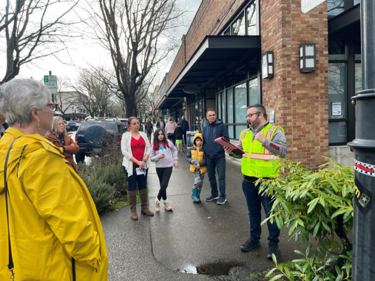 Brad Richardson (right), the executive director of the Clark County Historical Museum, leads a walking history tour throughtout downtown Camas during the Downtown Camas Association's "Spring into History" First Friday festivities on Friday, April 7, 2023. Richardson explained that the city of Camas grew up around the paper mill and was therefore configured not in an east-west or north-south arrangement like many other Clark County cities and towns. (Photos by Kelly Moyer/Post-Record)