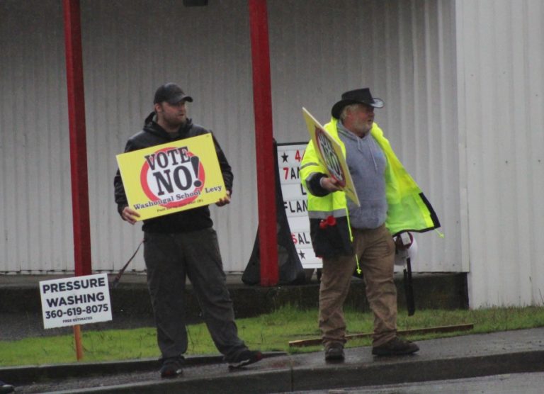 Washougal resident Glenn Kincaid (right) waves a &quot;vote no&quot; sign on the corner of &quot;E&quot; Street and Washougal River Road on Monday, April 10, 2023.
