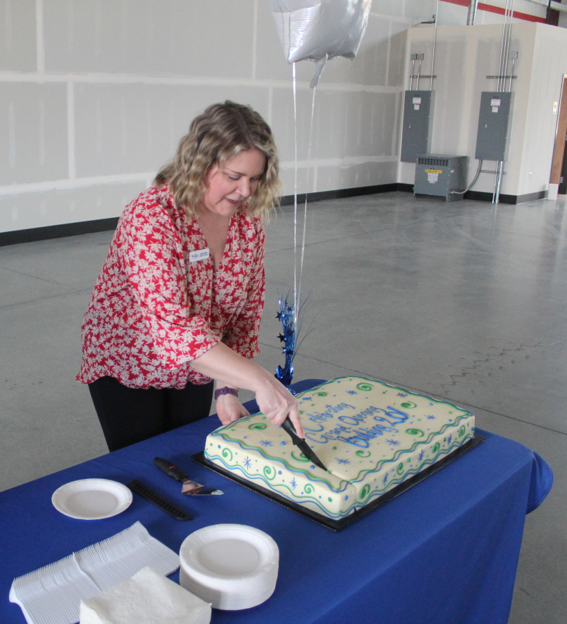 Port of Camas-Washougal finance director Krista Cagle cuts a cake during the Port's grand-opening event for its new industrial building in Washougal on Friday, April 14.