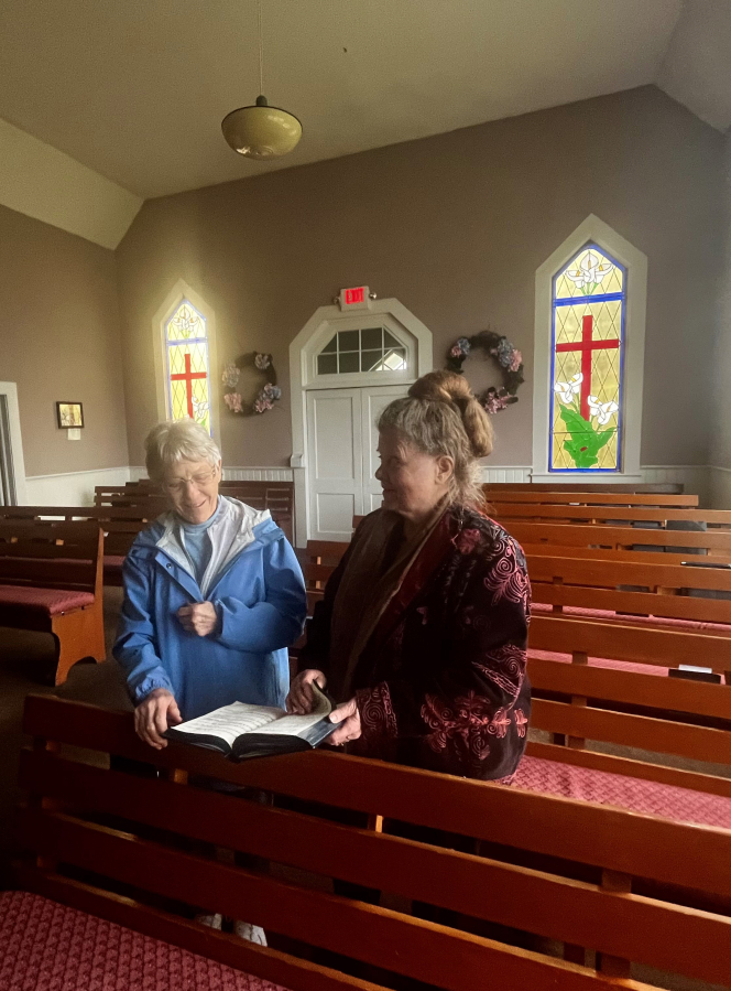 Kathy Kahlar (left) and Joan Hackett, sing hymns inside the historic Fern Prairie United Methodist Church on Monday, April 17, 2023.