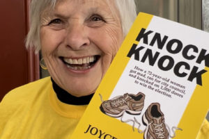 Former Washougal City Councilwoman Joyce Lindsay wears her trademark yellow campaign T-shirt and shows her new book, 