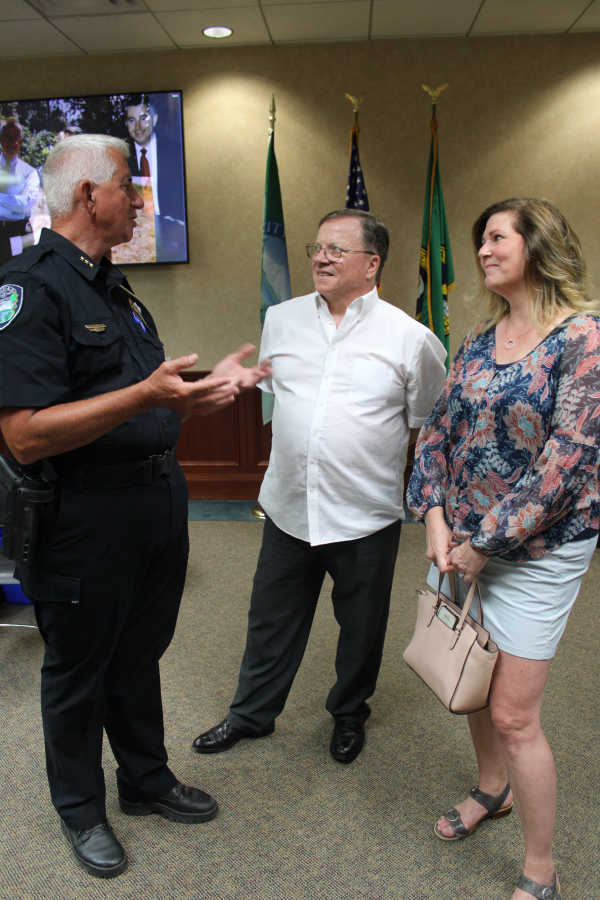 Camas Police Chief Mitch Lackey (left) talks to Camas Mayor Steve Hogan (center) and Camas City Councilwoman Bonnie Carter (right) during Lackey's retirement celebration Friday, June 30, 2023, at Camas City Hall.