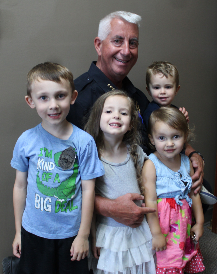 Camas Police Chief Mitch Lackey gathers with his four young grandchildren during his retirement reception Friday, June 30, 2023, at Camas City Hall. Lackey, who joined the Camas Police Department as a police officer in 1990, and became the department's chief in 2008, retired this month after a three-decade career in community policing.