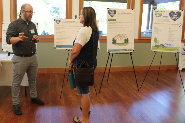 Geosyntec Consultants engineer Jacob Krall (left) discusses water-quality testing data collected from Lacamas, Round and Fallen Leaf lakes with a member of the public July 12, 2023, during a city of Camas open house at Lacamas Lake Lodge.