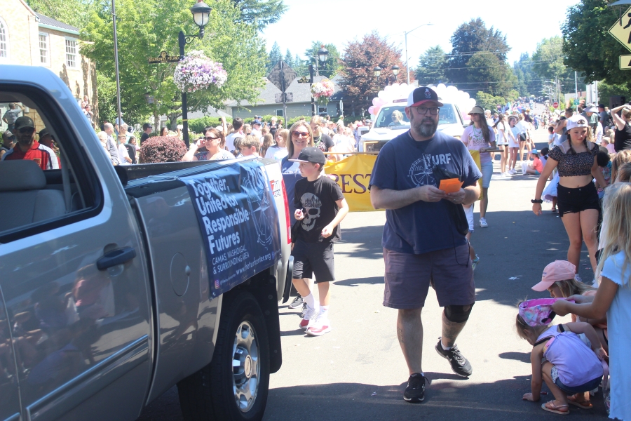 Doug Flanagan/Post-Record 
 Washougal resident Grant Gilson (right) passes out information about the Turf Teen Center to attendees during the 2023 Camas Days parade on Saturday, July 22, in downtown Camas.