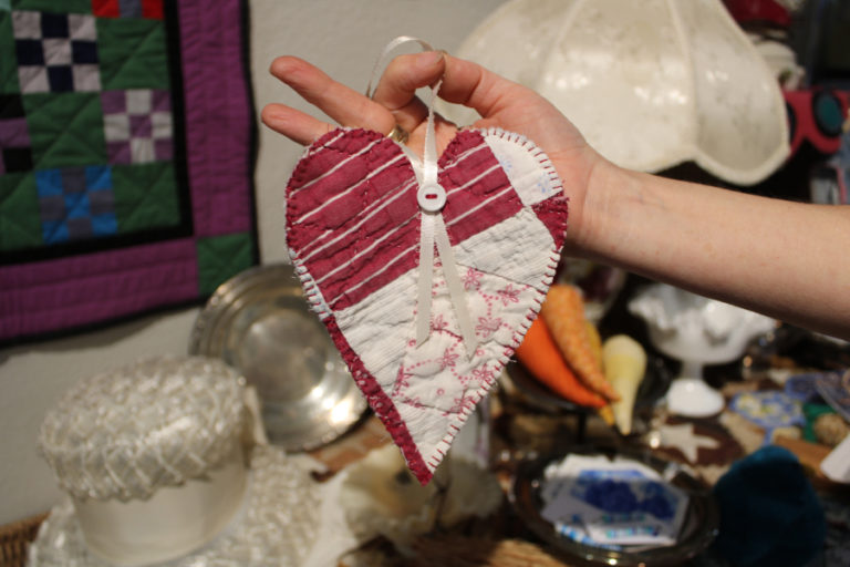 Bridge Island Arts and Vintage vendor Brandy Livingston holds a heart decoration made from an unusable quilt inside the newly opened Camas vintage and arts shop on Monday, July 31, 2023.