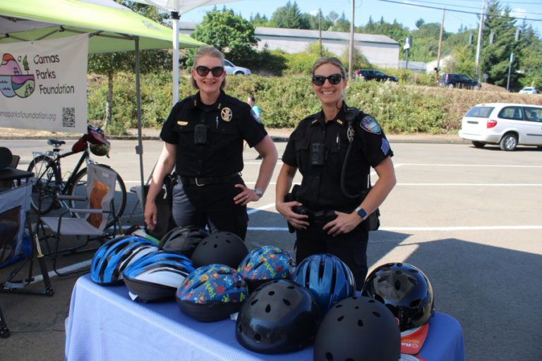 Camas Police Chief Tina Jones (left) and her officers hand out free helmets  Thursday, July 27, 2023, during a grand reopening event for Camas' Riverside Bowl Skatepark.
