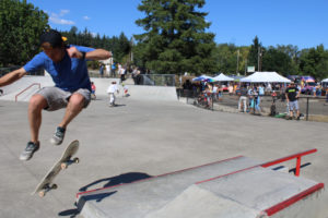 A skateboarder performs tricks at the newly remodeled Riverside Bowl Skatepark in Camas as crowds gather in the background for the park's grand reopening celebration on Thursday, July 27, 2023. (Photos by Kelly Moyer/Post-Record)