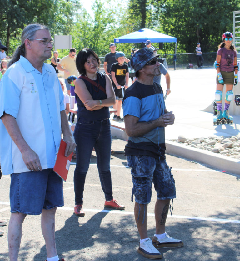 Camas Parks and Recreation Director Trang Lam (center), Washougal skateboarder Tim Laidlaw (left) and Washougal mural artist Kevin Seagraves (right) listen to Camas Mayor Steve Hogan (not pictured) speak Thursday, July 27, 2023, during the grand reopening of the Riverside Bowl Skatepark in Camas.