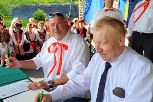Washougal Mayor David Stuebe (left) and Boguslaw Krol, the mayor of Zielonki, Poland, sign a sister-city agreement during a community festival in Zielonki in June 2023. (Contributed photo courtesy of the city of Zielonki, Poland)