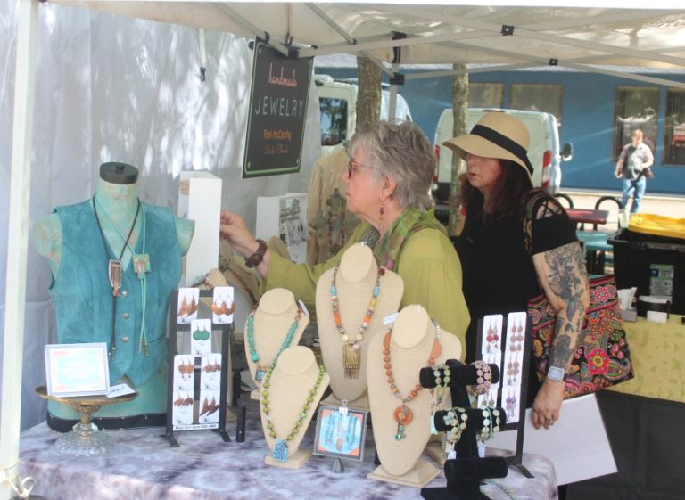 Toni McCarthy (left) of Toni McCarthy Designs talks about her artwork with an attendee during the 2023 Washougal Art Festival, held Saturday, Aug. 12, 2023, at Reflection Plaza in downtown Washougal.
