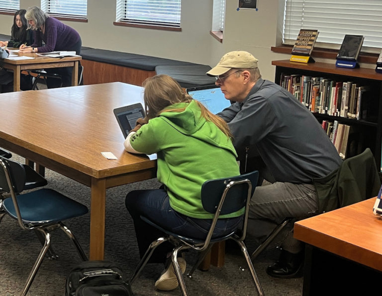 Contributed photo courtesy Barb Seaman 
 Community-School Partnership volunteer Mark Haller (right) helps a Washougal High School student with a project for a financial Fitness class earlier this year. (Contributed photo courtesy of Barb Seaman)