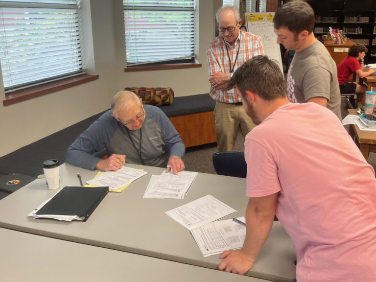 Contributed photo courtesy Barb Seaman 
 Community-School Partnership volunteers John Neumann (left) and John Latta (second from left), and teacher Lukas Johnson (right) look over a geometry assignment with a Washougal High School student earlier this year.