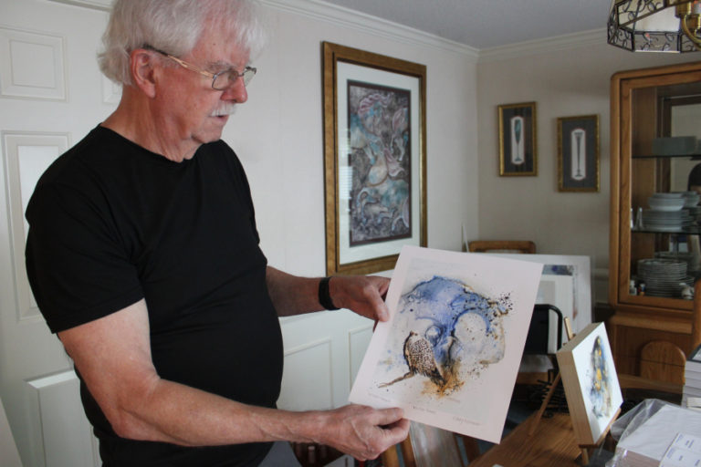 Gary Watson shows the "Winter Hawk" art print he plans to give away to the first 40 visitors to the Aurora Gallery's Sept. 16 art reception for "Art and Sew Forth," the joint show featuring the artwork of Watson and his wife, quilting artist Deborah Watson.