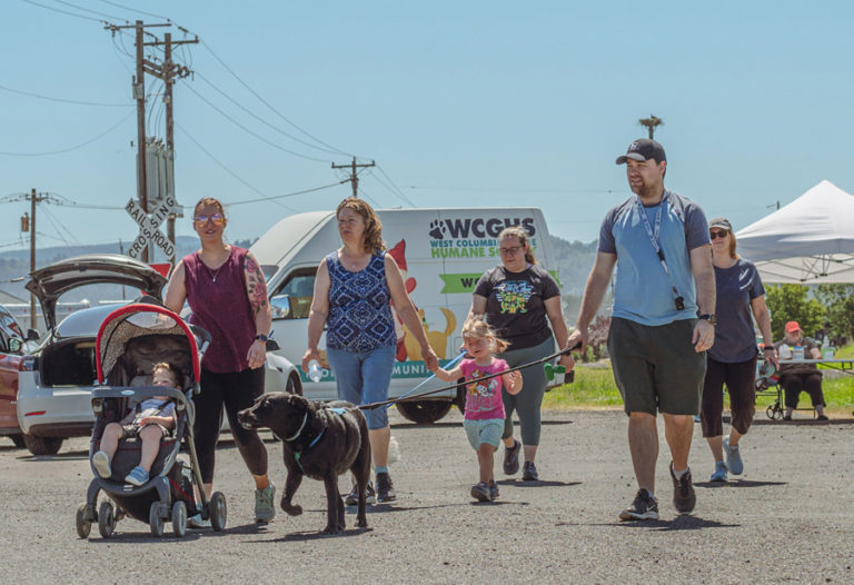 Attendees walk their dog during the annual Hike on the Dike fundraising event in Washougal June 25, 2022.