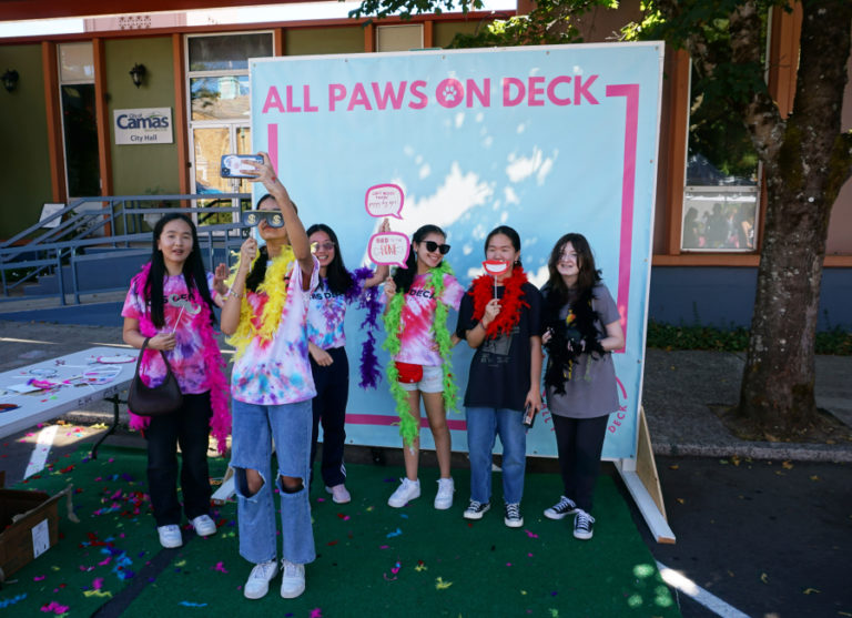 Youngsters use the photo book at the All Paws on Deck street fair in downtown Camas in September 2022.