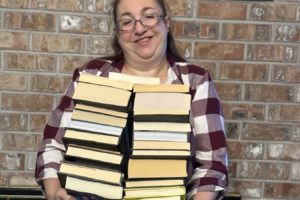 Cascadia Northwest Real Estate agent Tabitha Schmer holds donated books that will be given to the Friends of the Washougal Library group. The Clark County-based real estate firm is holding an event on Friday, Sept. 29, 2023, to raise funds for the Fort Vancouver Regional Library's Washougal library project. (Contributed photo courtesy of Tabitha Schmer)