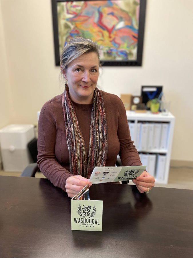Reed Creative owner Lori Reed holds a Washougal Brew Pass in her downtown Washougal office on Monday, Sept. 25, 2023.