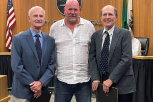 Doug Danielson (left) and William Danielson (right) stand with  Washougal Mayor David Stuebe (center) after receiving the city of Washougal's 