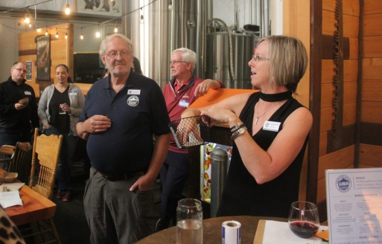 Doug Flanagan/Post-Record 
 Washougal Business Association board member Margaret Rice (right) selects a raffle ticket during an open house event on Thursday, Oct. 12, at 54-40 Brewing Company in Washougal. (Doug Flanagan/Post-Record)