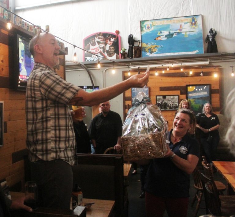 Doug Flanagan/Post-Record 
 Washougal Business Association board member Bolt Minister reads the number of a winning raffle ticket during an open house event on Thursday, Oct. 12, at 54-40 Brewing Company in Washougal.