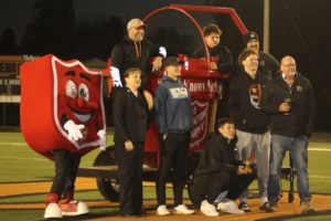 Washougal High School senior Holden Bea (crouching, center) holds a trophy and gathers with his 