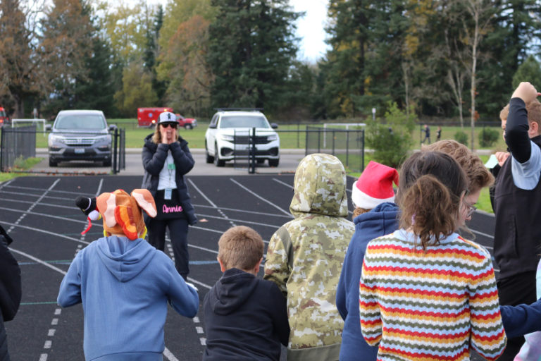 Contributed photo courtesy Washougal School District 
 Annie Thomas (background), the co-cordinator of the Columbia River Gorge Elementary School's Boosters Mileage Club, talks to students at the Jemtegaard Middle School track earlier this year.