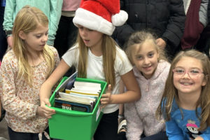 Washougal students accept a literacy donation from the Camas-Washougal Rotary Club in December 2023. (Contributed photo courtesy Camas-Washougal Rotary) 