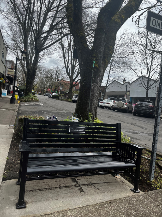 A bench with a plaque reading, "In Hospitality, Camas Boutique Hotel" adopted by Camas Hotel owners Bobby Sachdeva and Prashant Gupta, is pictured April 21, 2023, at the corner of Northeast Cedar Street and Northeast Fourth Avenue in downtown Camas . The Downtown Camas Association (DCA), in collaboration with the city of Camas, launched its adopt-a-bench program in the spring of 2022, to help replace benches in the city’s historic downtown. The DCA has had 17 benches adopted, with three more benches available, for a total value of $51,000 as of Dec. 18, 2023.