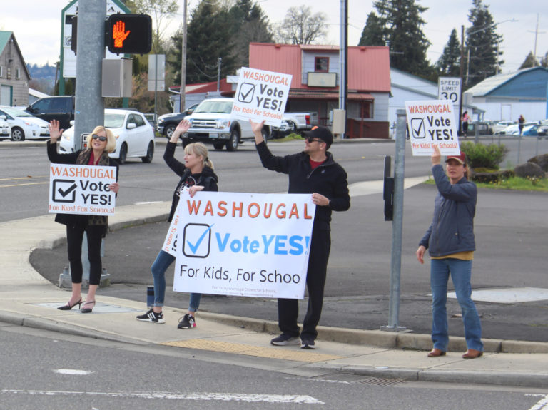 Sign-wavers urging people to "vote yes!" on the Washougal School District's two replacement levies stand near levy opponents at the corner of "E" Street and Washougal River Road on April 10, 2023.
