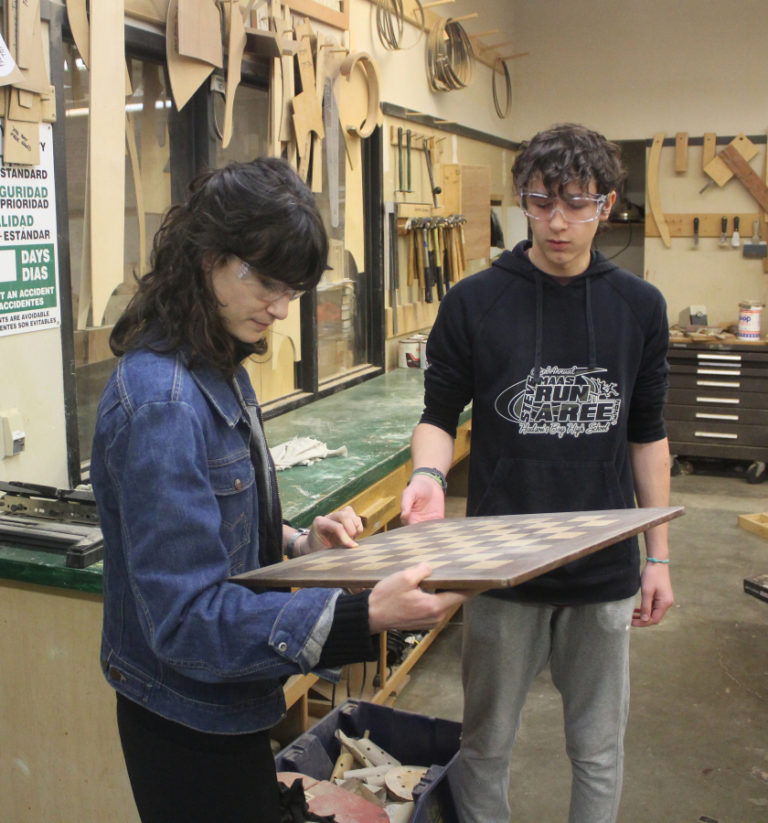 U.S. Rep. Marie Gluesenkamp Perez, D-Skamania (left), asks Washougal High School sophomore Brandon Lee about his woodshop project at Washougal High on Wednesday, Jan.