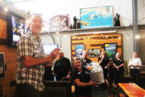 54-40 Brewing Company owner Bolt Minister (left) reads a raffle ticket number during a Washougal Business Association event in October 2023. The company’s new location at the Evergreen Marketplace in Washougal will allow its original location at the Port of Camas-Washougal to host more events, according to Minister. (Doug Flanagan/Post-Record)