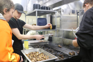 Washougal High School Culinary Arts Instructor Alexandra Yost (left), and students Drake Leifsen (center) and Jackson Lockard (right) prepare kabobs inside the Shoug Shack food truck, Friday, Feb. 16, 2024. (Contributed photo courtesy of the Washougal School District)